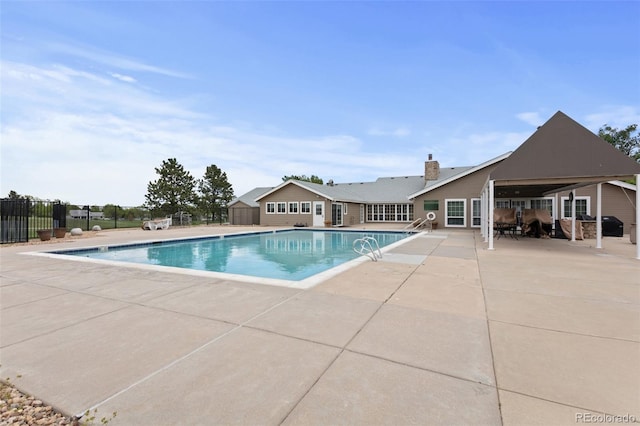 community pool with a patio and fence