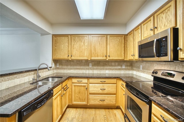 930 Button Rock Dr Unit 29, Longmont, CO 80504 - kitchen featuring appliances with stainless steel finishes, dark stone counters, backsplash, and light wood-type flooring