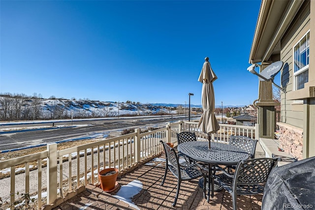 snow covered deck with a mountain view