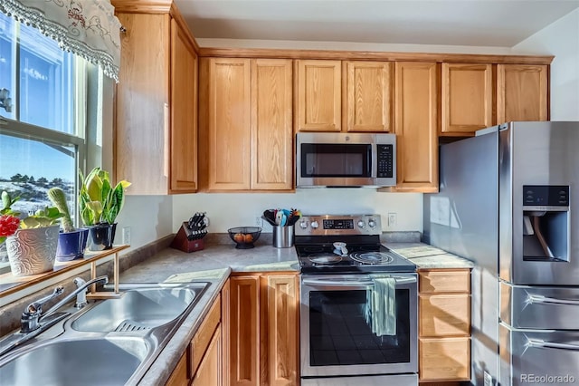 kitchen featuring stainless steel appliances, light countertops, and a sink