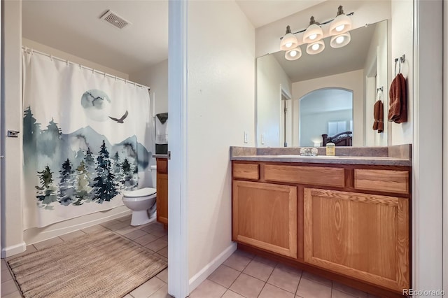 bathroom with visible vents, toilet, vanity, tile patterned flooring, and baseboards