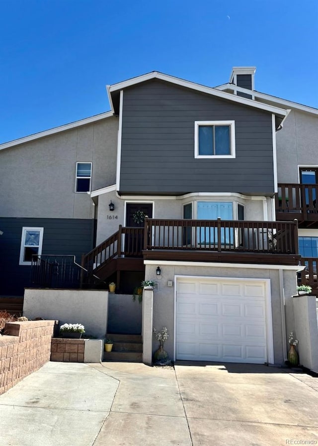 view of front of property with a garage, driveway, stairs, and stucco siding