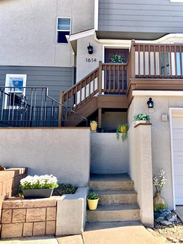 property entrance featuring a balcony and stucco siding