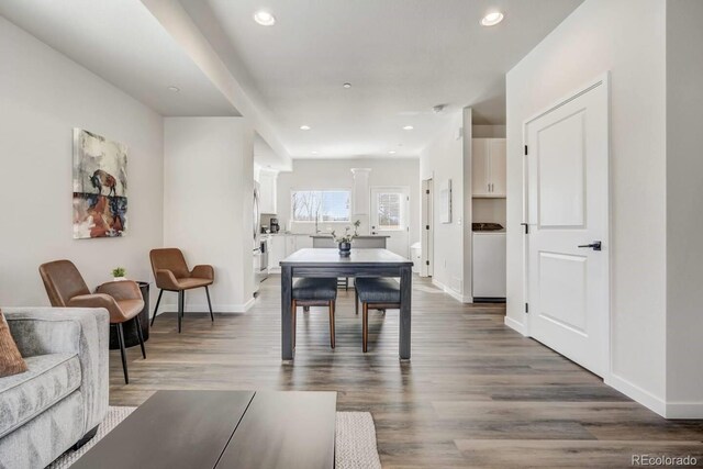 dining space with baseboards, wood finished floors, and recessed lighting