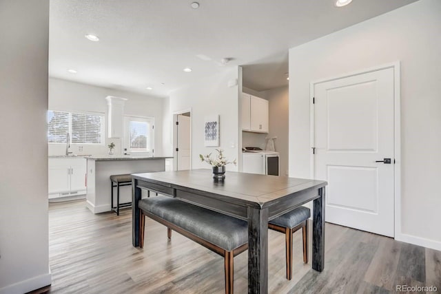 dining room featuring light wood-style flooring, baseboards, independent washer and dryer, and recessed lighting