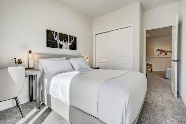 carpeted bedroom featuring baseboards and a closet