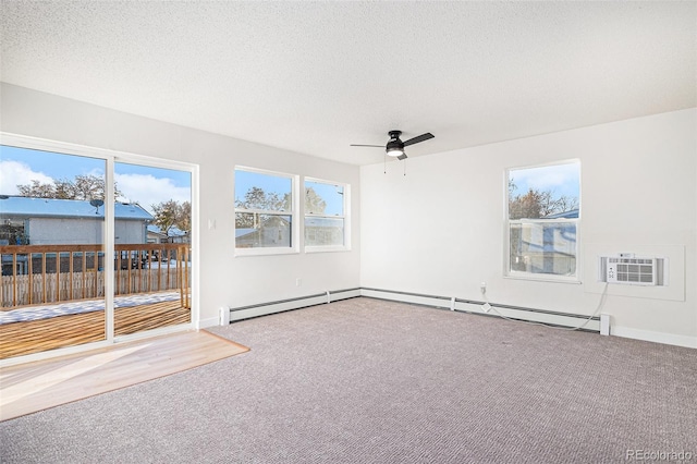 spare room featuring a wall unit AC, a textured ceiling, ceiling fan, and carpet floors