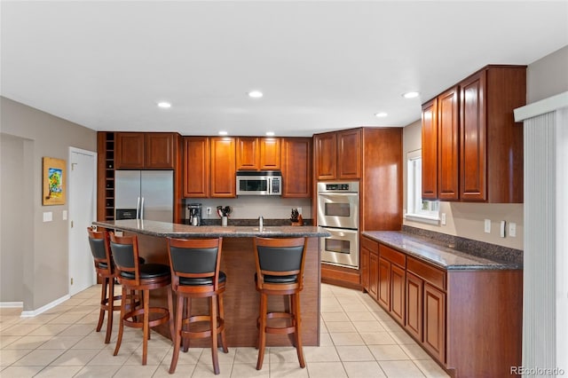 6143 S Ash Cir E, Centennial, CO 80121 - kitchen featuring stainless steel appliances, a kitchen breakfast bar, light tile patterned flooring, and recessed lighting
