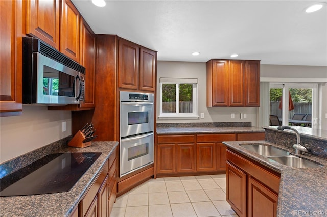 6143 S Ash Cir E, Centennial, CO 80121 - kitchen featuring appliances with stainless steel finishes, plenty of natural light, recessed lighting, light tile patterned floors, and brown cabinetry
