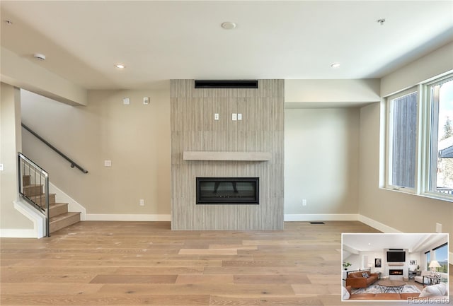 living room with light hardwood / wood-style floors and a fireplace