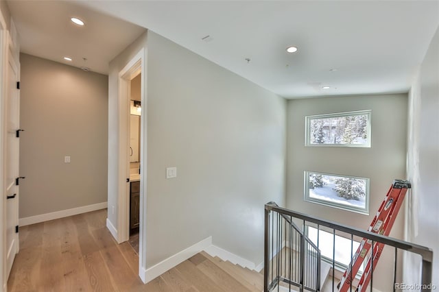 hall with lofted ceiling and light wood-type flooring