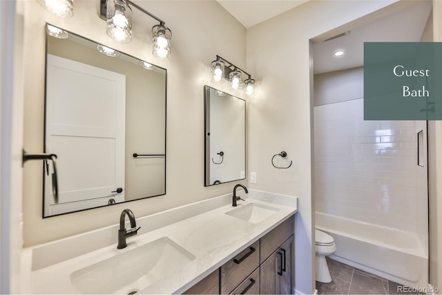 full bathroom featuring vanity, toilet, tiled shower / bath, and tile patterned flooring