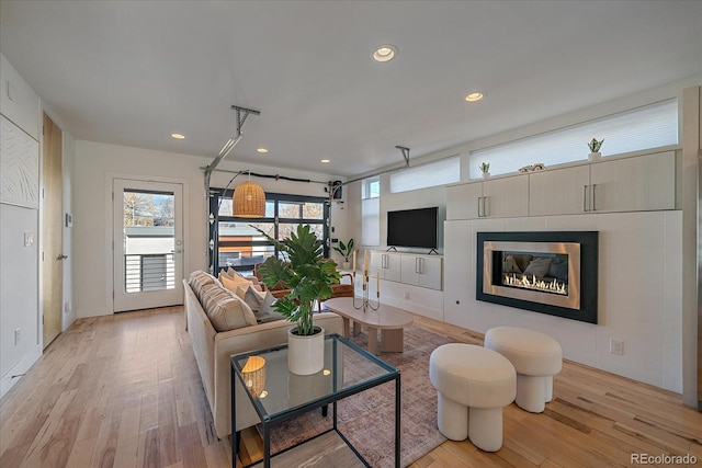 living room with light wood-type flooring and recessed lighting