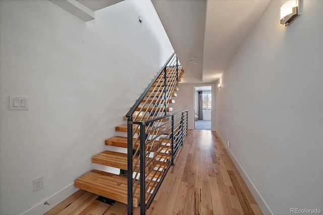 stairs featuring hardwood / wood-style flooring and baseboards