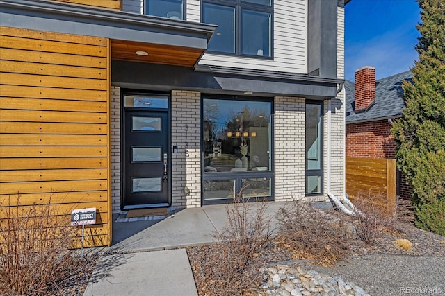 view of exterior entry with brick siding