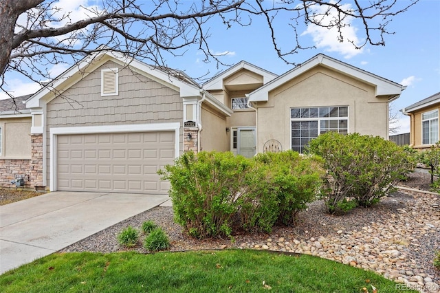 22312 E Plymouth Cir, Aurora, CO 80016 - view of front of house featuring an attached garage, driveway, stucco siding, and stone siding