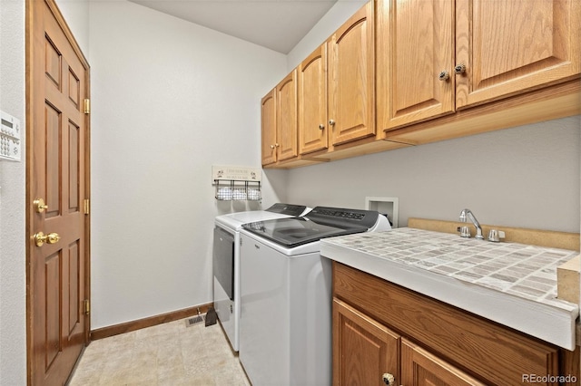 22312 E Plymouth Cir, Aurora, CO 80016 - washroom with cabinet space, baseboards, and washer and clothes dryer