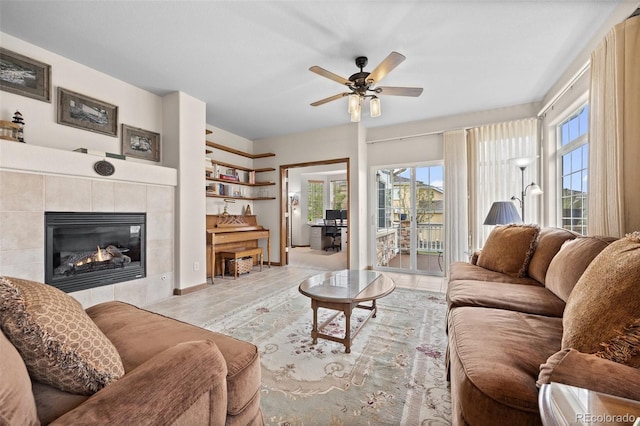 22312 E Plymouth Cir, Aurora, CO 80016 - living room featuring a tiled fireplace, ceiling fan, and baseboards