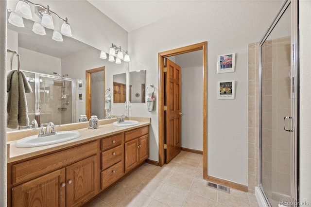 22312 E Plymouth Cir, Aurora, CO 80016 - full bathroom featuring a shower stall, double vanity, tile patterned floors, and baseboards