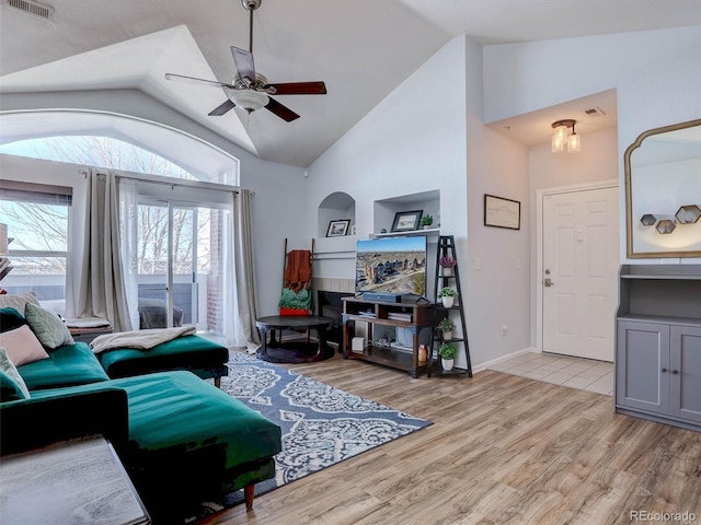 living room with high vaulted ceiling, ceiling fan, and light wood-type flooring