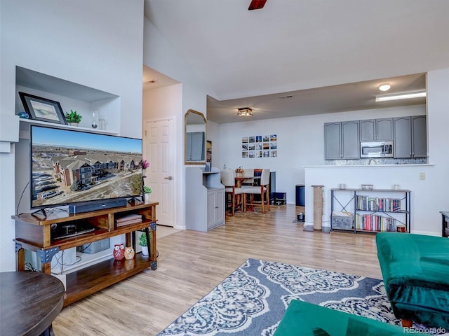 living room featuring light hardwood / wood-style floors and ceiling fan