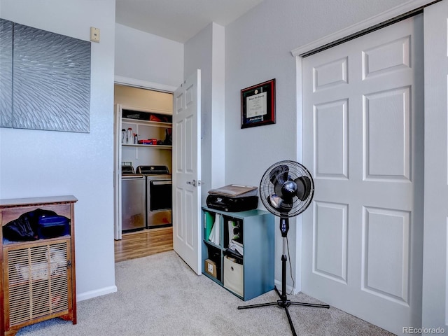 miscellaneous room with light carpet and washer and clothes dryer