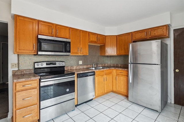 kitchen with tasteful backsplash, sink, light tile patterned flooring, and stainless steel appliances