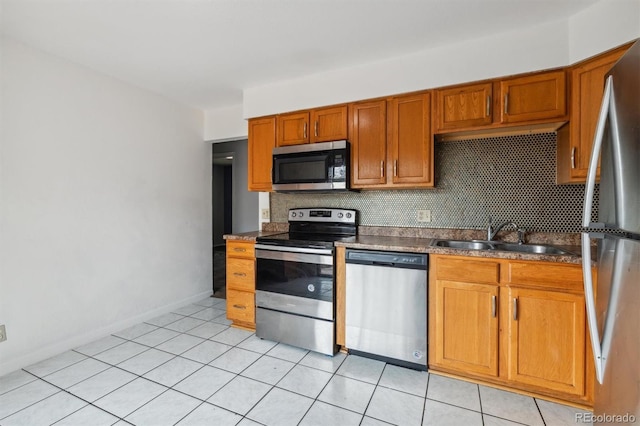 kitchen featuring decorative backsplash, sink, light tile patterned floors, and stainless steel appliances