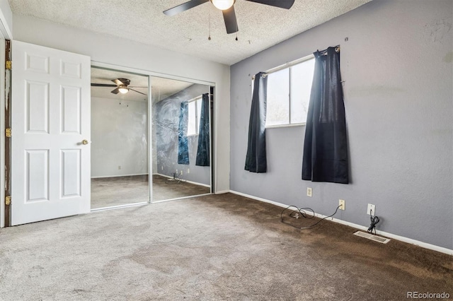 unfurnished bedroom with ceiling fan, a closet, carpet floors, and a textured ceiling