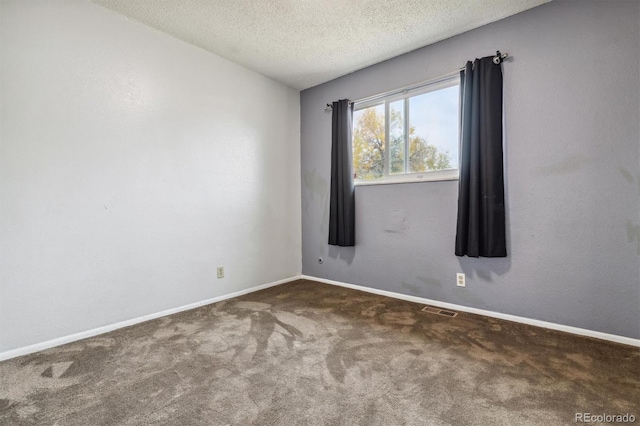 unfurnished room featuring dark colored carpet and a textured ceiling