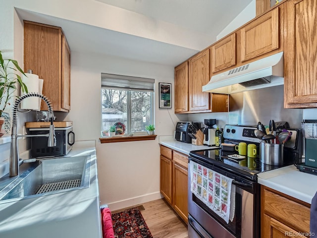 kitchen featuring electric range, light hardwood / wood-style flooring, and vaulted ceiling