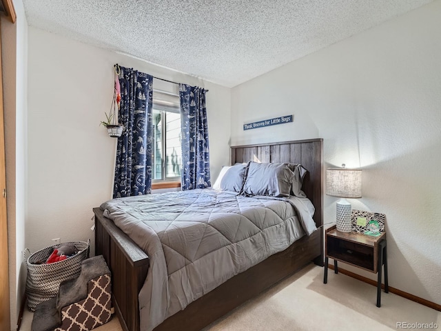 bedroom with a textured ceiling and light colored carpet