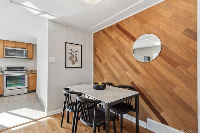 tiled dining room featuring wooden walls