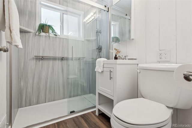 bathroom with toilet, a shower with door, vanity, and hardwood / wood-style flooring