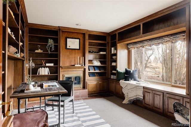 home office with light carpet, built in shelves, and a large fireplace