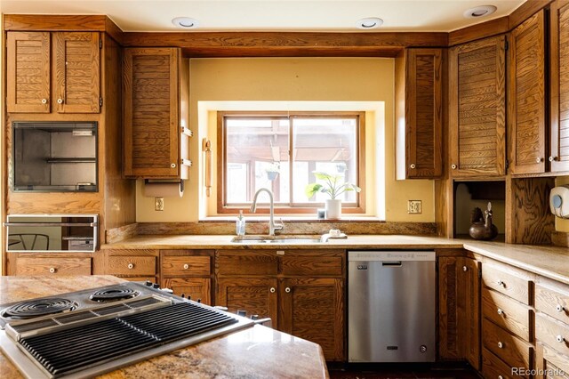 kitchen with brown cabinets, dishwasher, light countertops, and a sink