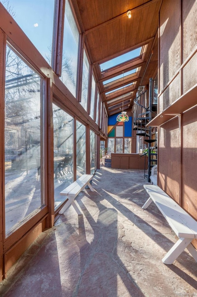 sunroom / solarium with wood ceiling, a healthy amount of sunlight, and a skylight