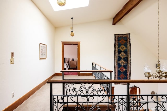 hall featuring lofted ceiling with skylight, carpet, and baseboards