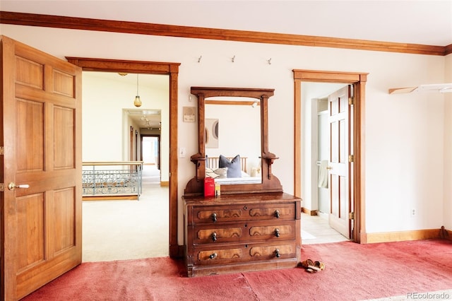 hall featuring light colored carpet, crown molding, and baseboards