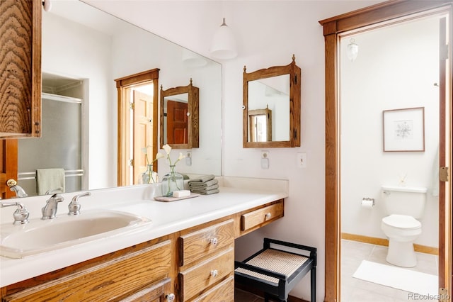 bathroom featuring vanity, baseboards, a stall shower, tile patterned floors, and toilet