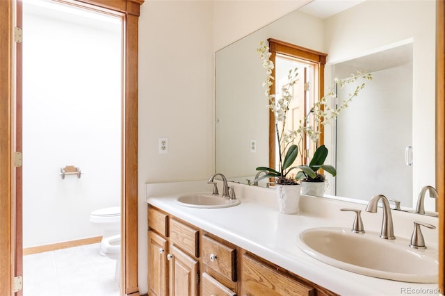 full bath featuring double vanity, tile patterned floors, toilet, and a sink