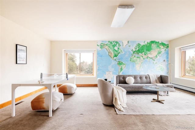 carpeted living area featuring a skylight, baseboard heating, baseboards, and a wealth of natural light