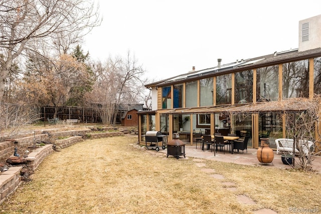 back of property featuring a patio, a lawn, and fence