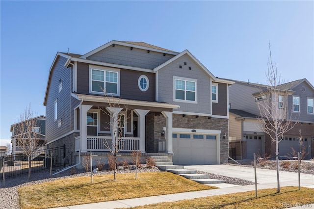 view of front of home with an attached garage, covered porch, fence, concrete driveway, and stone siding