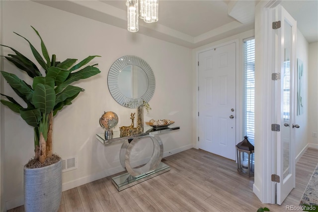 entryway with baseboards, visible vents, and light wood-style floors