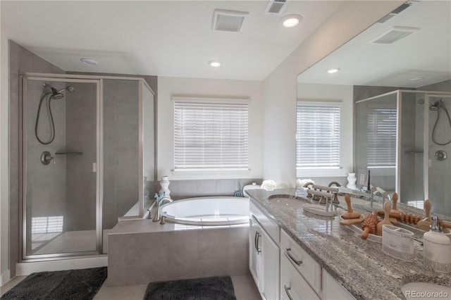 bathroom with a stall shower, visible vents, and vanity