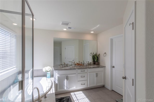 8240 S White Crow St, Aurora, CO 80016 - bathroom featuring healthy amount of natural light, double vanity, tile patterned flooring, and a tub to relax in