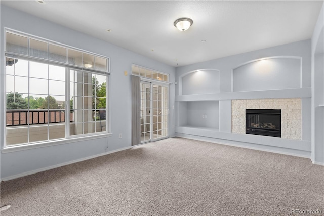 12711 Colorado Blvd Unit 1116, Thornton, CO 80241 - unfurnished living room featuring carpet, a glass covered fireplace, baseboards, and built in shelves