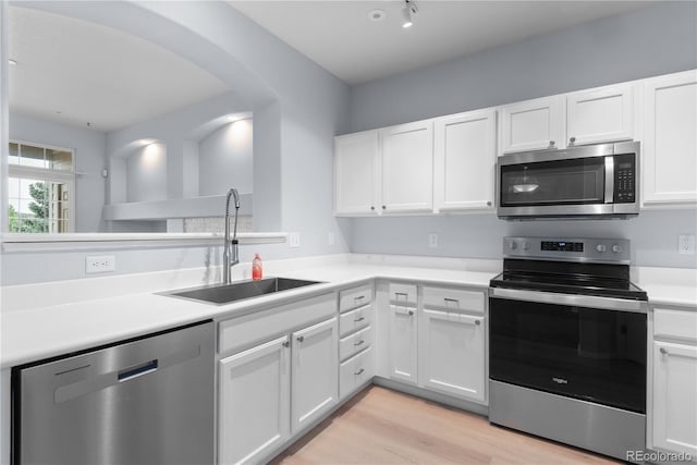 12711 Colorado Blvd Unit 1116, Thornton, CO 80241 - kitchen featuring stainless steel appliances, a sink, arched walkways, white cabinetry, and light countertops
