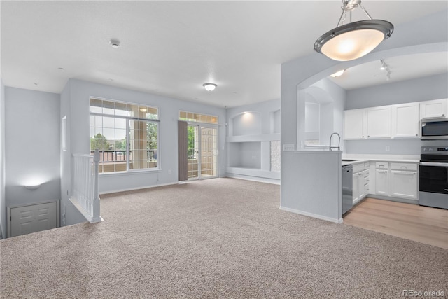 12711 Colorado Blvd Unit 1116, Thornton, CO 80241 - kitchen with appliances with stainless steel finishes, light carpet, open floor plan, white cabinetry, and a sink